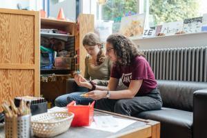 2 Jugendliche stellen im Jugendhaus Origami-Figuren her